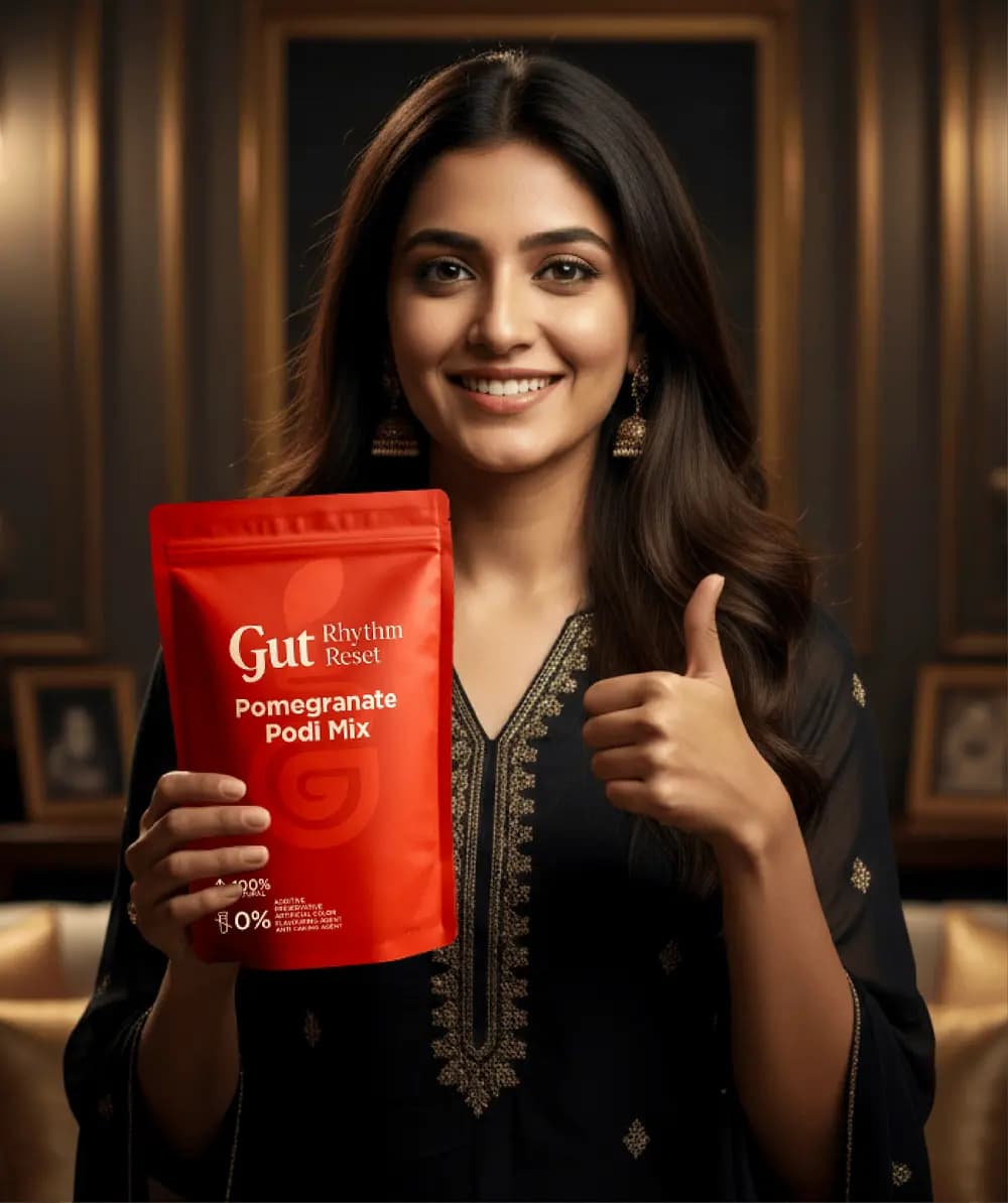 A smiling woman holding a Pomegranate Podi Mix pouch with a thumbs up