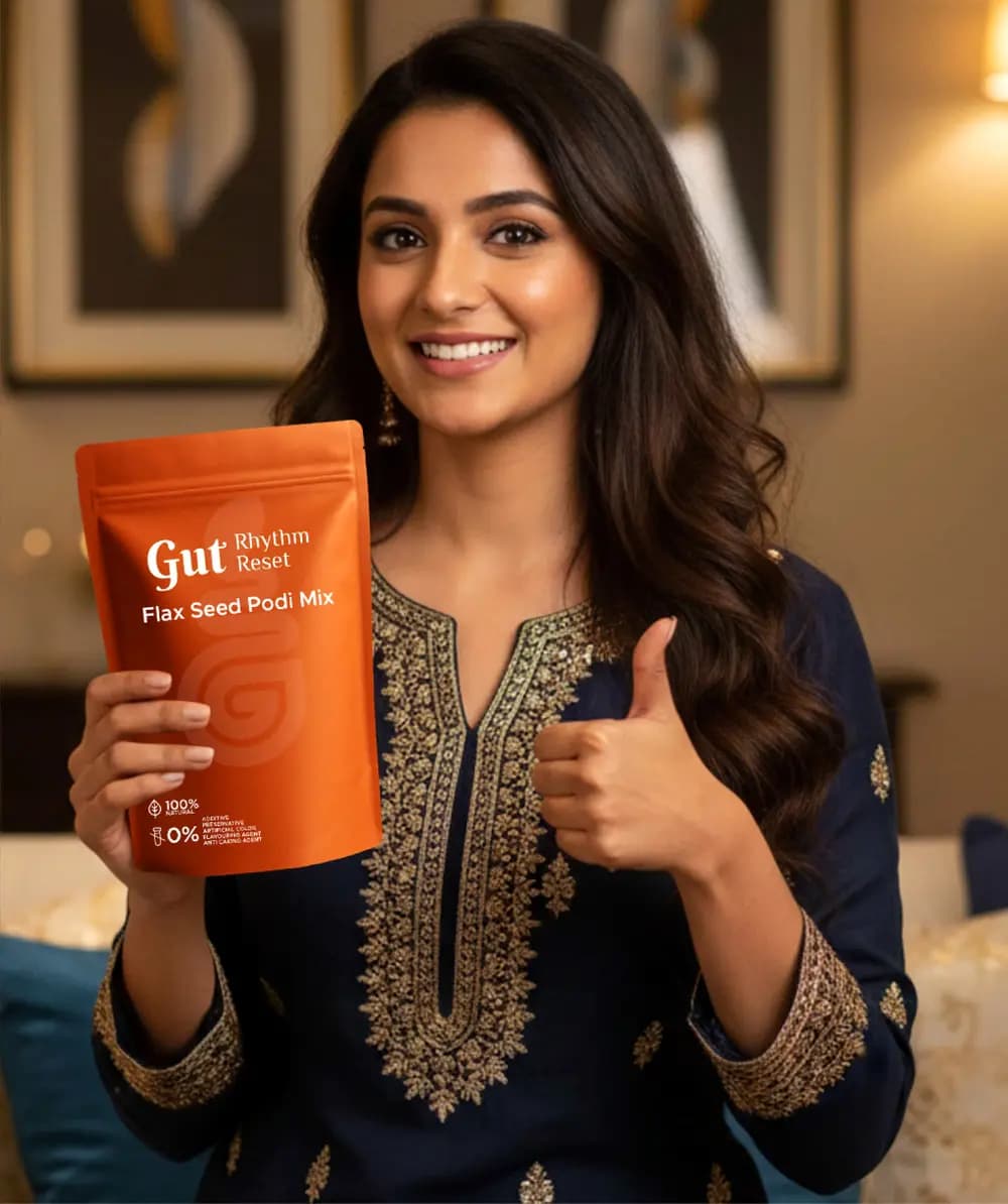A smiling woman holding a Flax Seed Podi pouch with a thumbs up