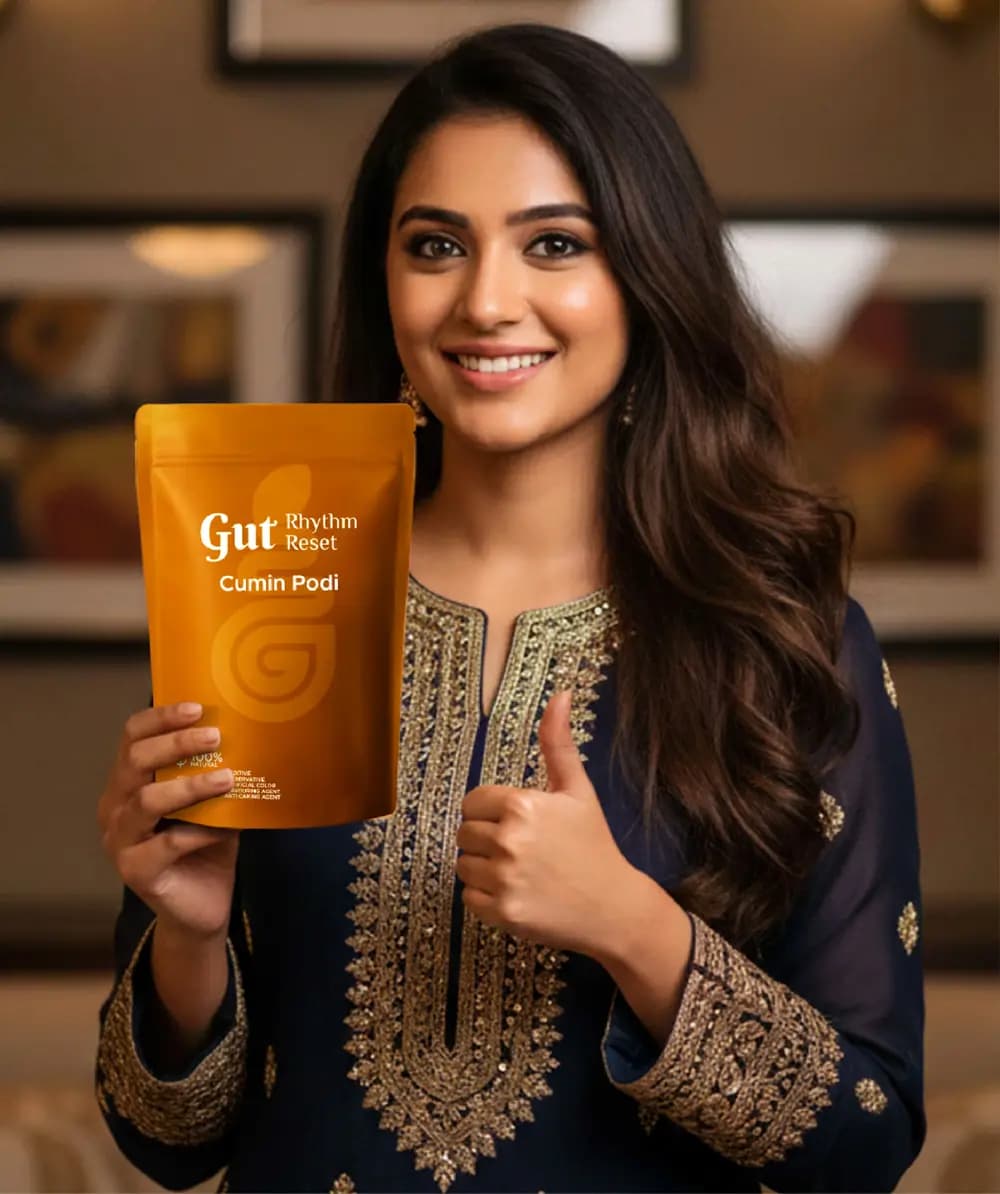 A smiling woman holding a Cumin Podi pouch with a thumbs up